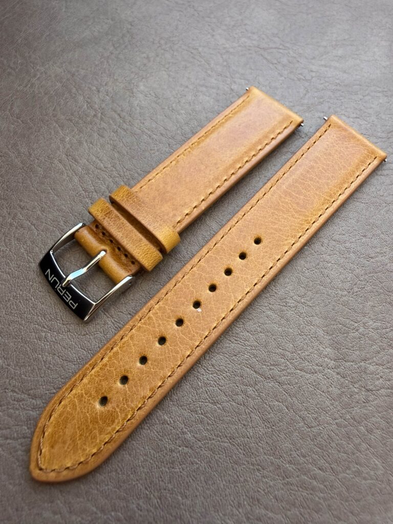 Cognac leather strap on a leather backdrop