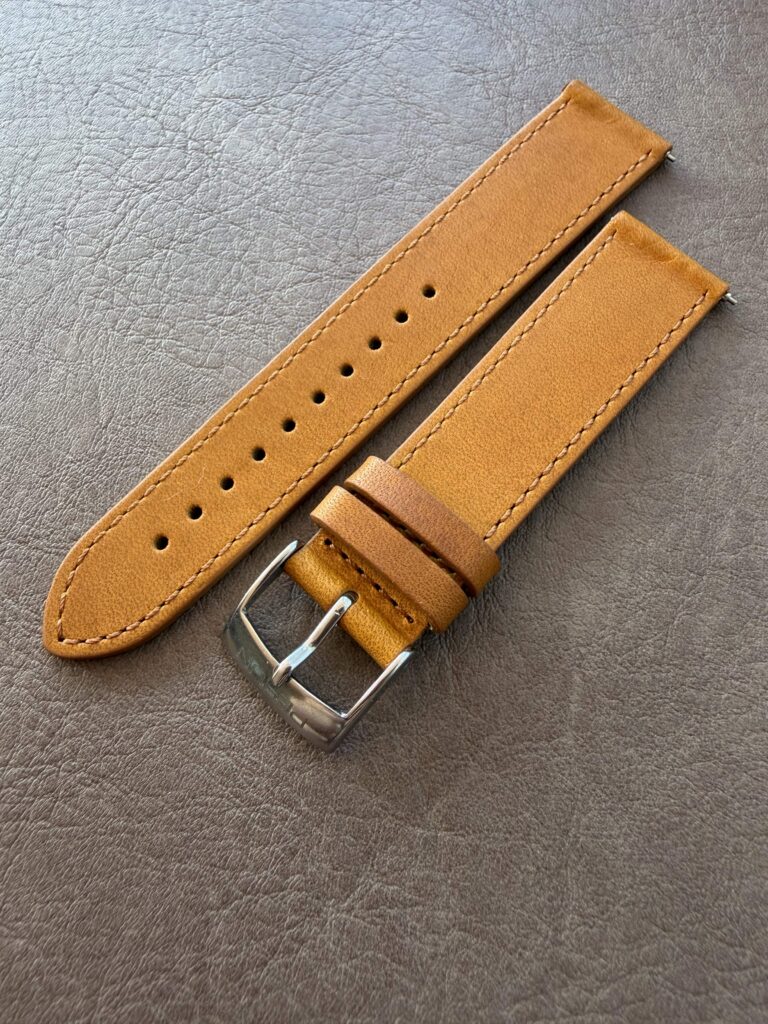 Matte cognac leather strap on a leather backdrop