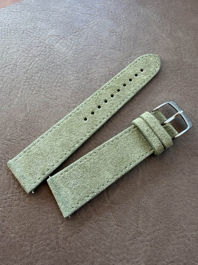 Sage suede strap on a leather backdrop