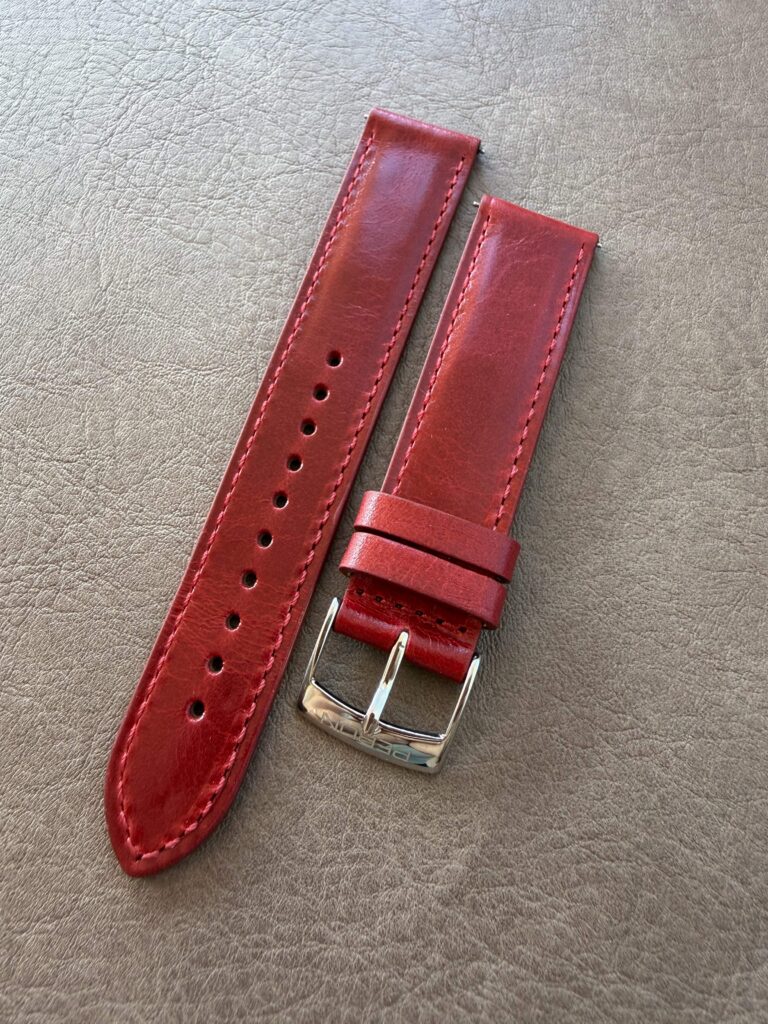 Crimson leather strap on a leather backdrop