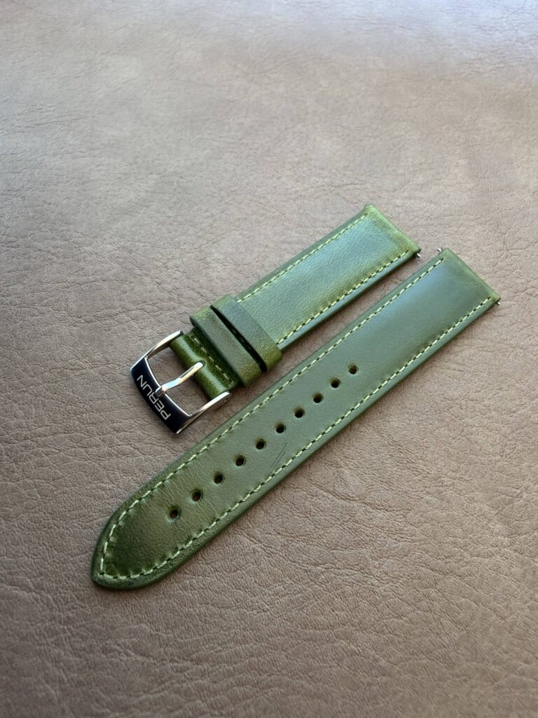 Moss green leather strap on a leather backdrop