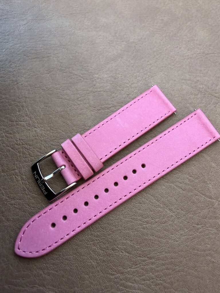 Pink leather strap on a leather backdrop