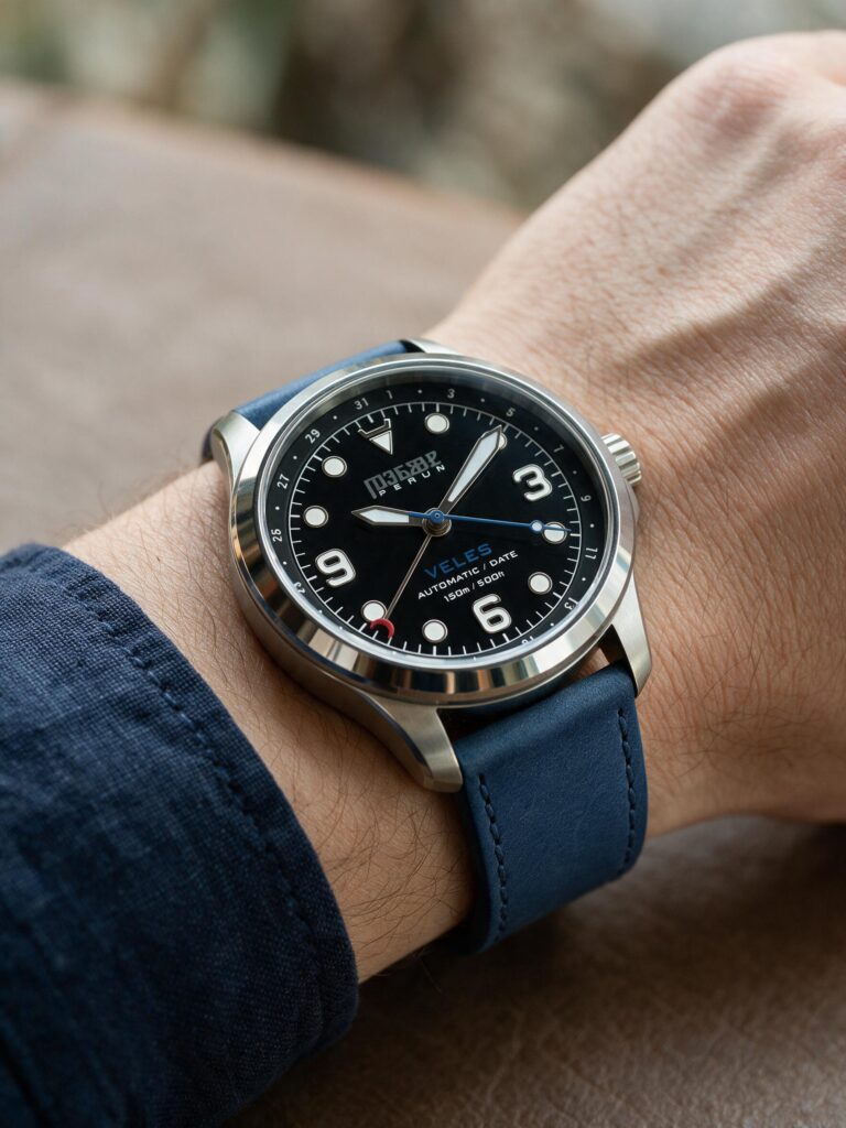Veles Midnight Black on the wrist, on a marine blue leather strap