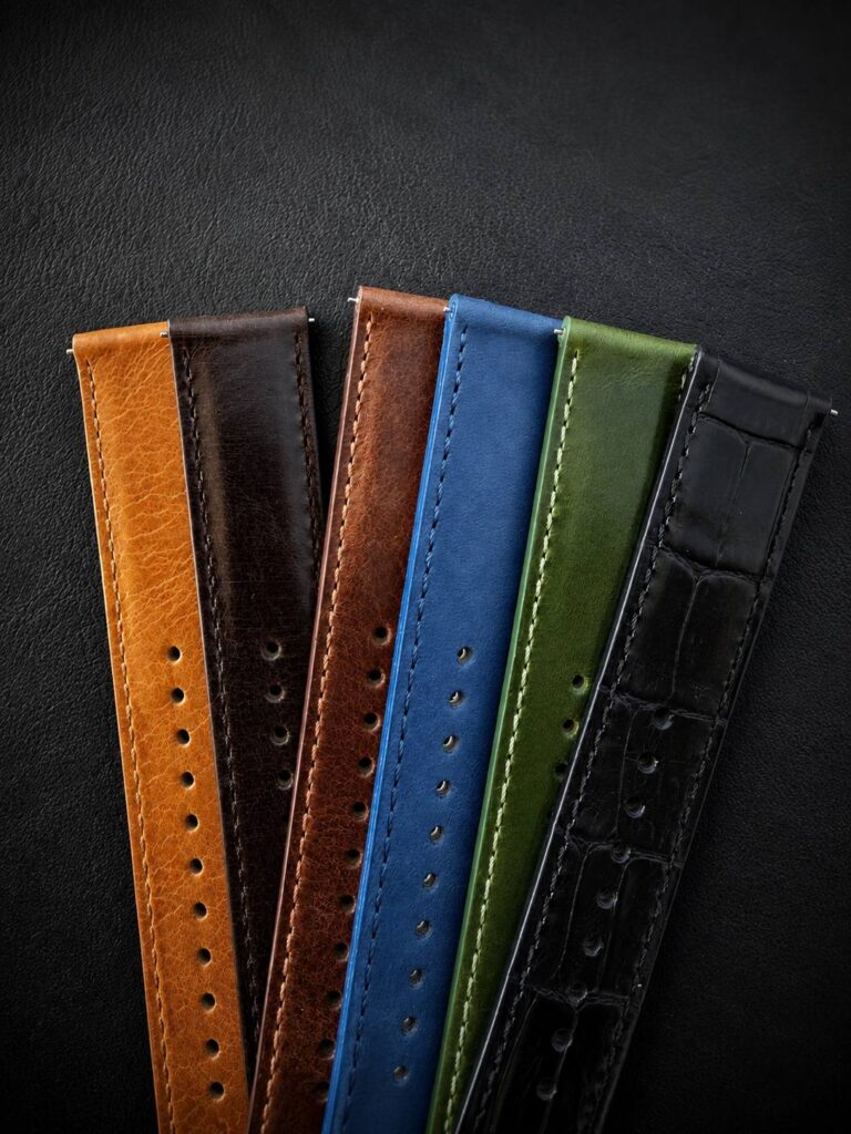 Five Perun leather straps fanned out: cognac, brown, blue, green and black