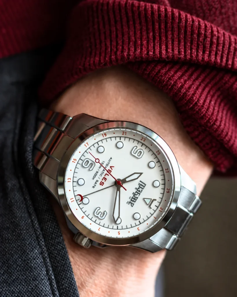 Veles Pearl White on the wrist with a burgundy sweater sleeve